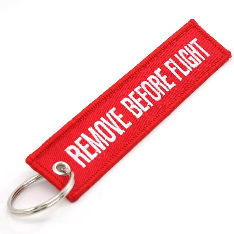 Red keychain with 'REMOVE BEFORE FLIGHT' text on a white background