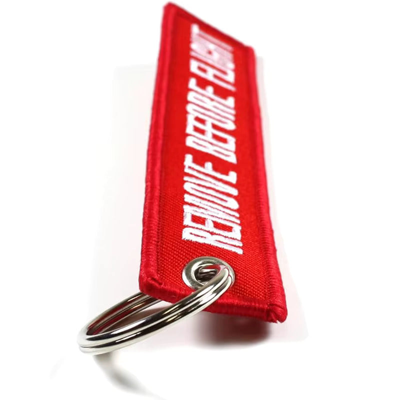 Red keychain with 'REMOVE BEFORE FLIGHT' text on a white background