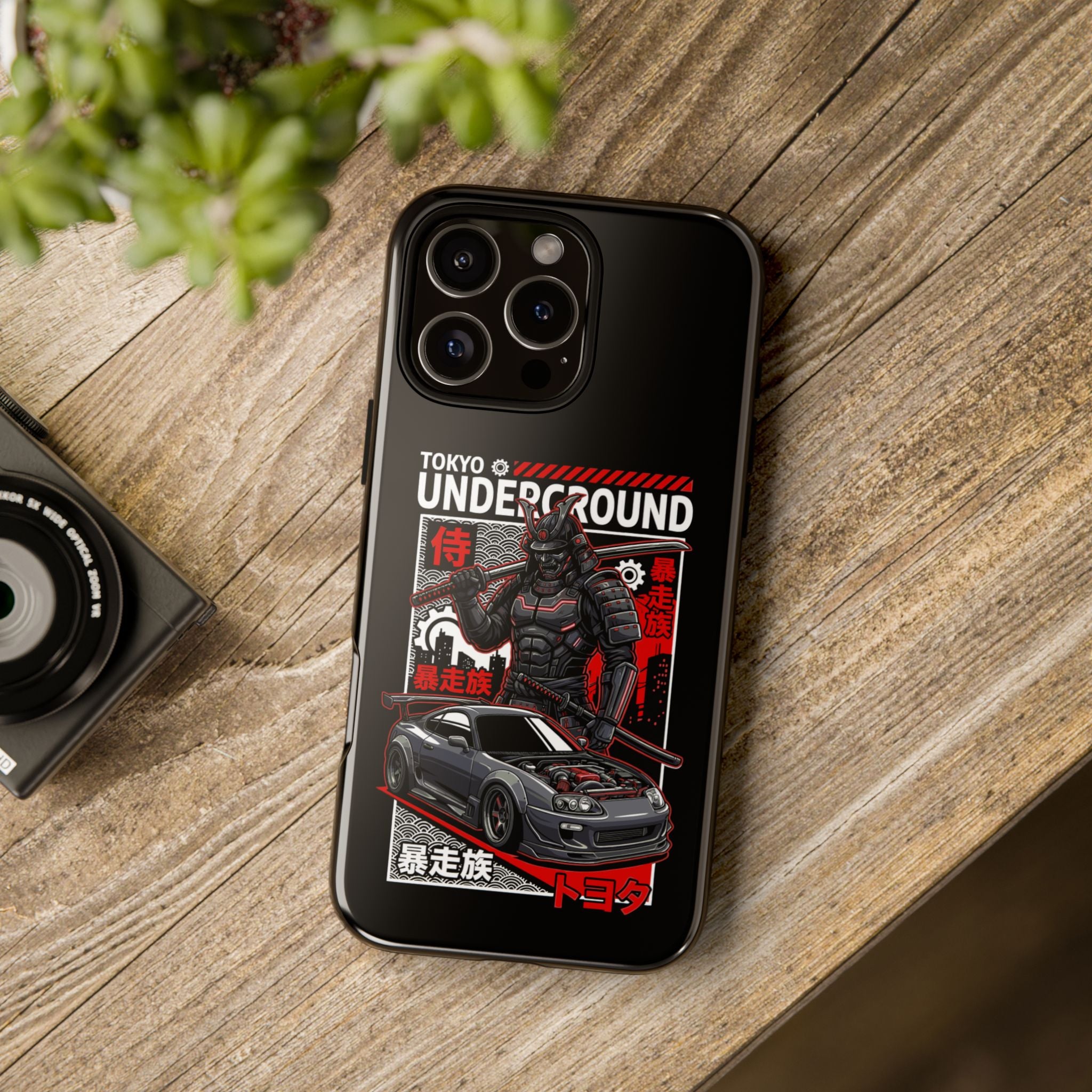 Black phone case with TOKYO UNDERGROUND text, A Toyota Supra MK4, and a Samurai.