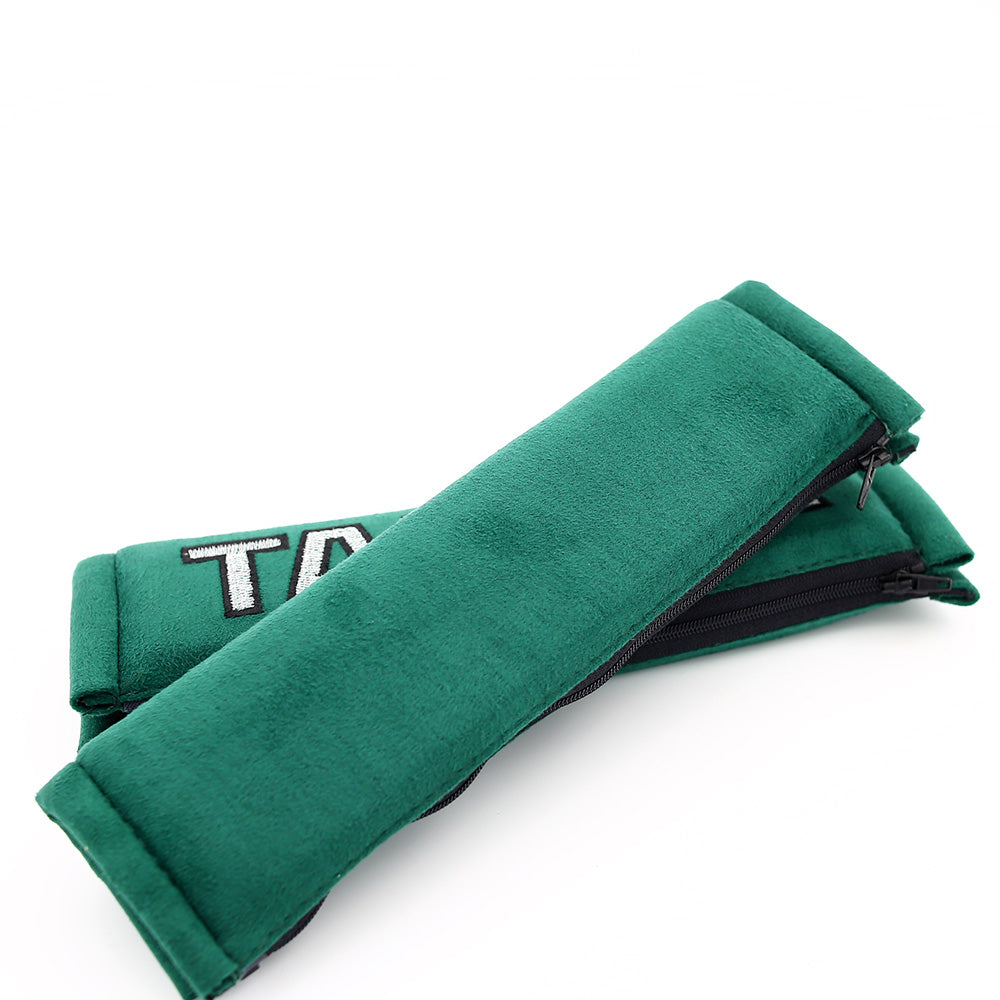 A pair of takata comfort seat belt shoulder pads in green.