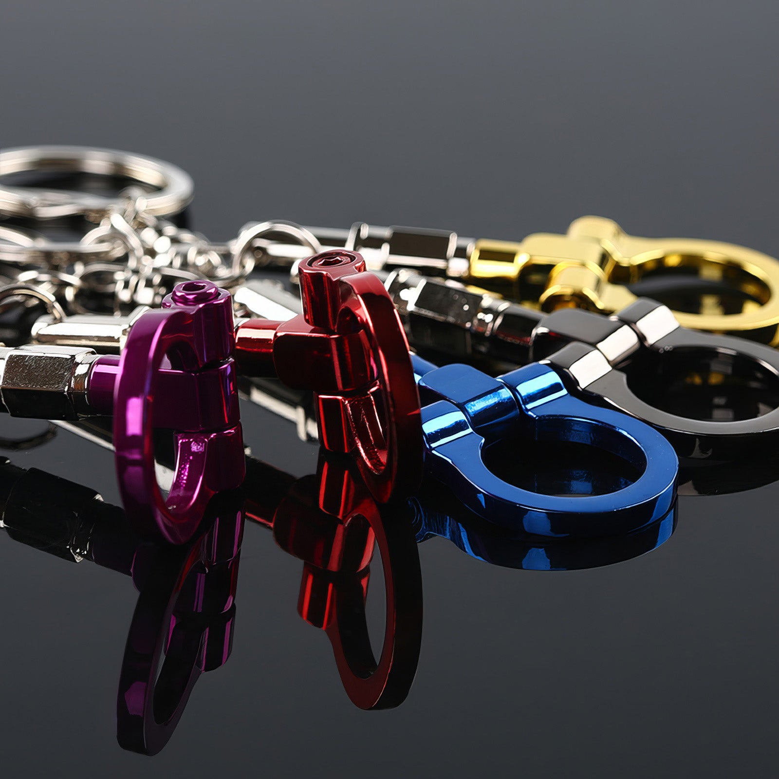 Tow hook keychains with purple, red, blue, black, and gold hooks.