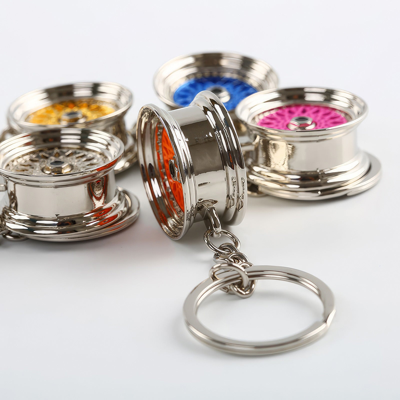 BBS Mesh Wheel keychains with pink, orange, blue, and gold center.