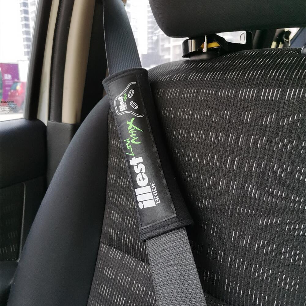 Bride illest JDM seat belt shoulder pads in black installed in car.