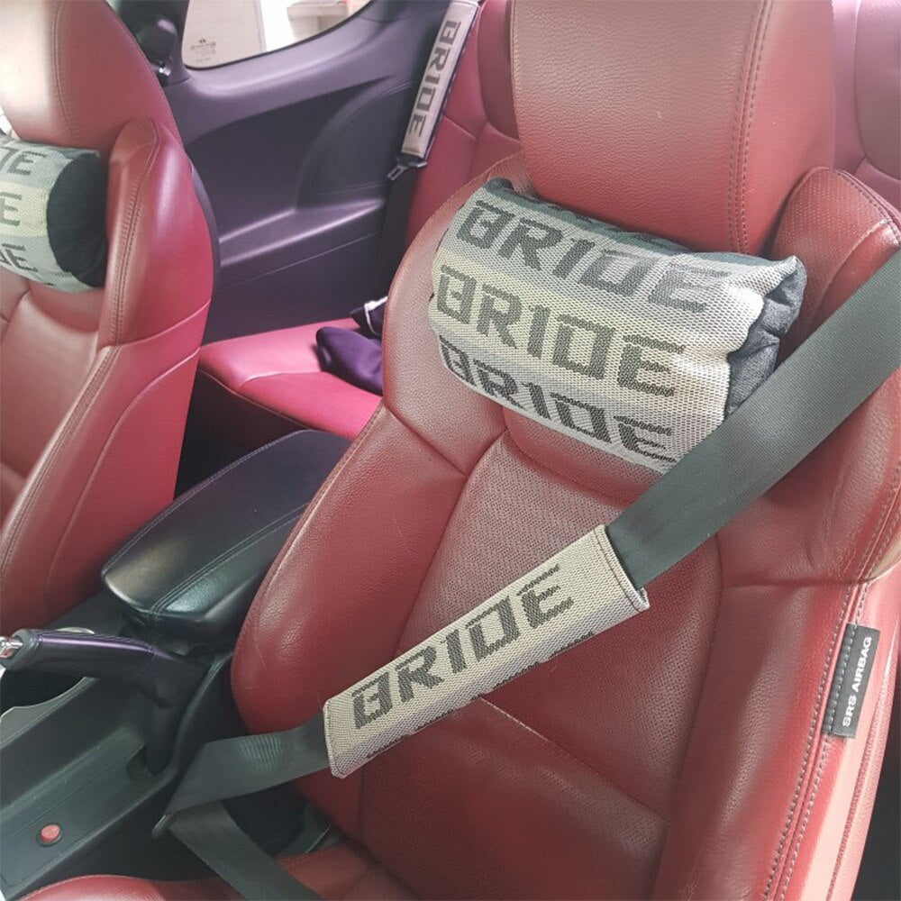 Bride racing fabric seat belt shoulder pads in beige installed in car.