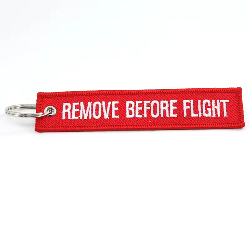 Red keychain with 'REMOVE BEFORE FLIGHT' text on a white background