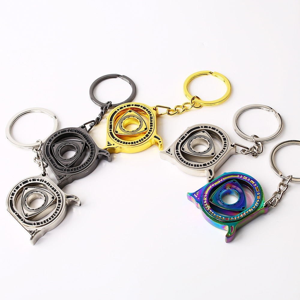 Spinning Rotary Engine Keychain in silver, black, gold, and neochrome.