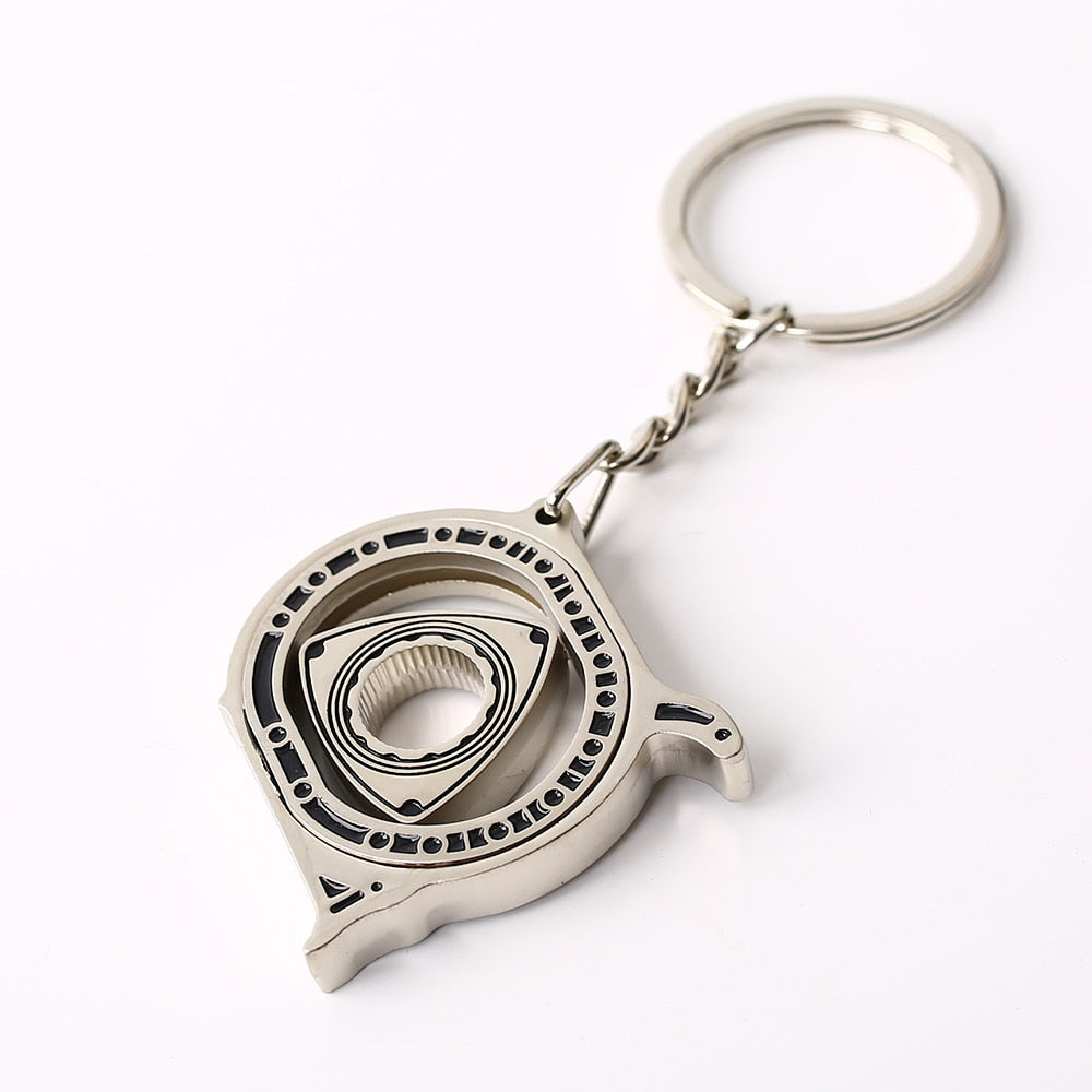 Spinning Rotary Engine Keychain in matte silver.
