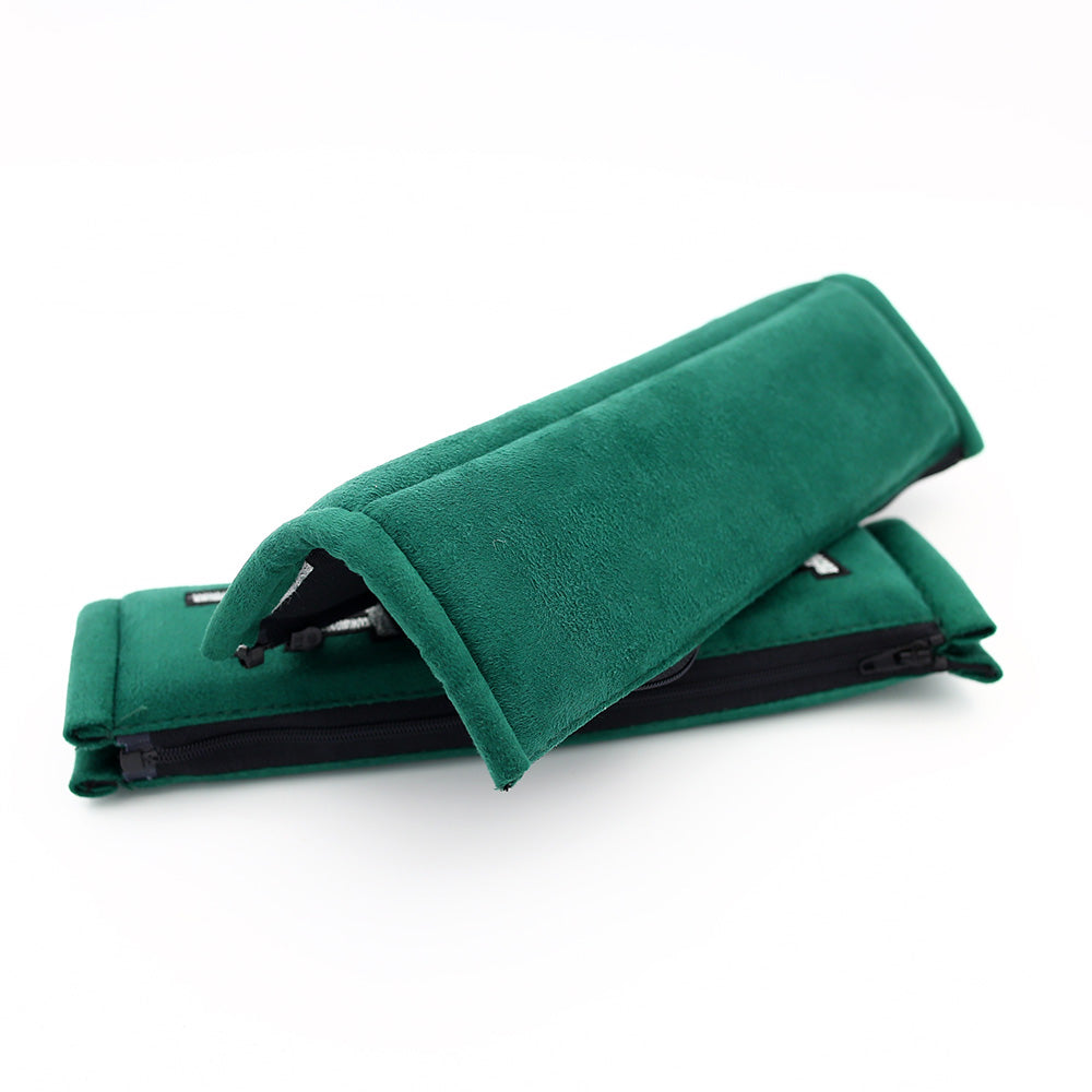 A pair of takata comfort seat belt shoulder pads in green.